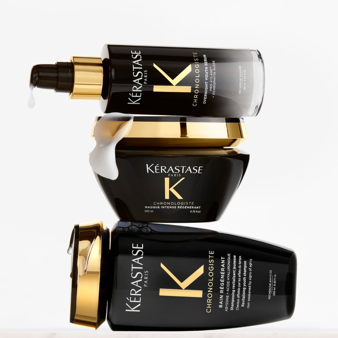 Stacked luxury Kérastase Chronologiste hair care products including shampoo, hair mask, and youth serum