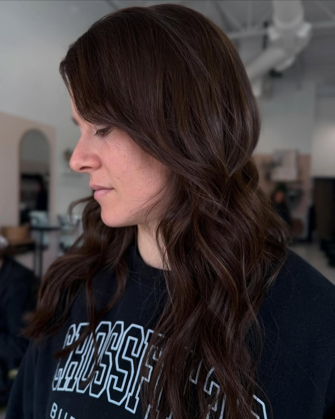 Long dark brown layered hair featuring extensions for thinning hair by Jessica.