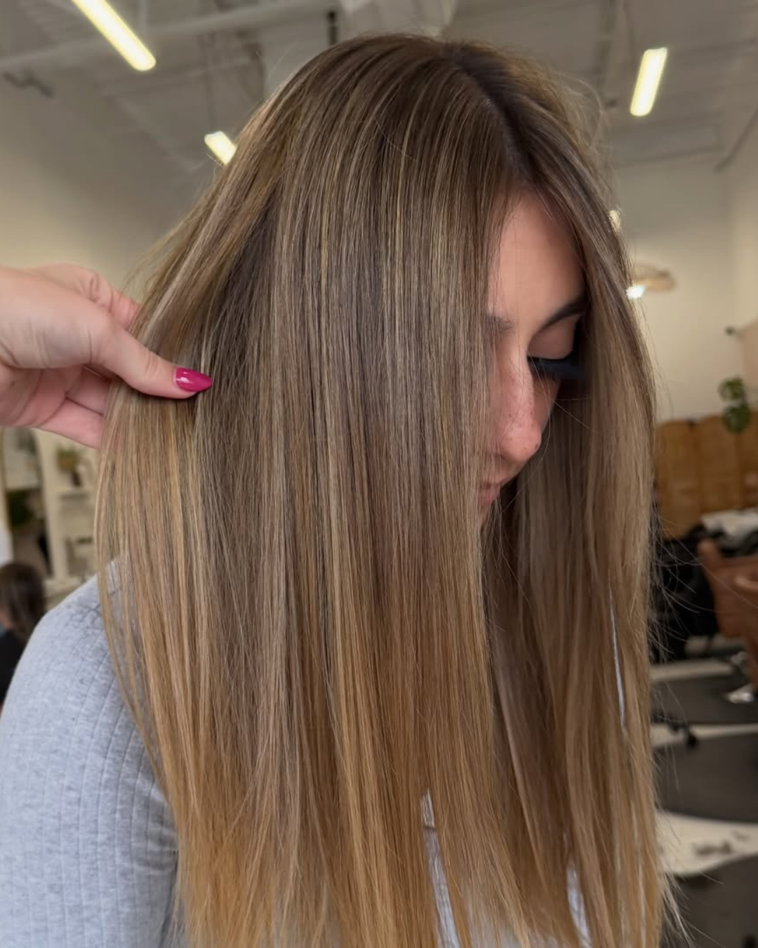 Close-up of straight, long hair with blended honey blonde and light brown highlights.