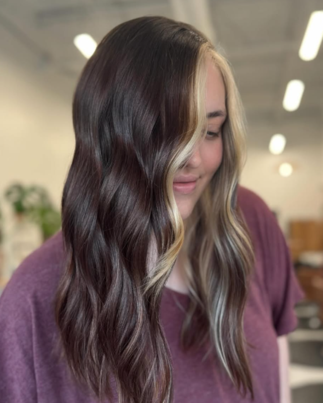 Dark brown hair with blonde money-piece highlights featuring color blocking by Zoe.