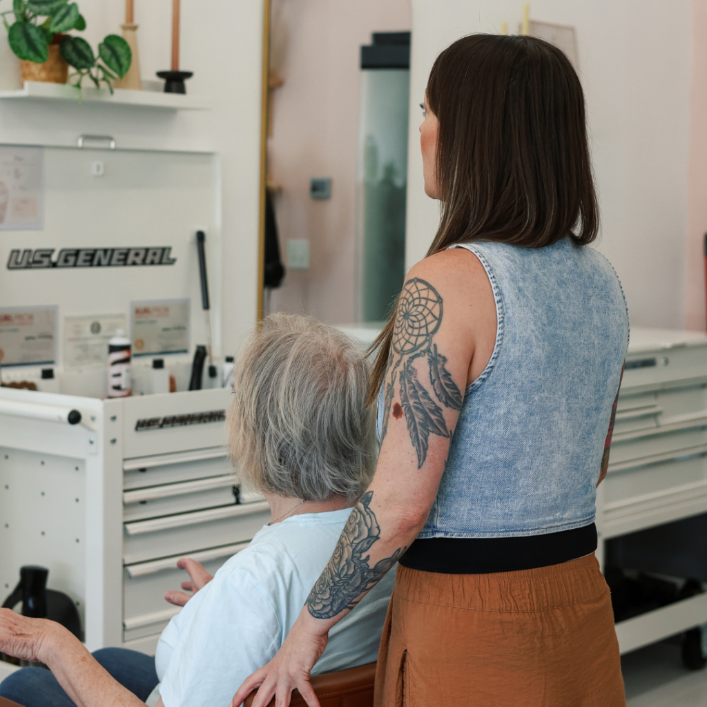 Stylist with a tattoo sleeve consulting with a client at Dwell Studio Salon in Fort Worth, TX.