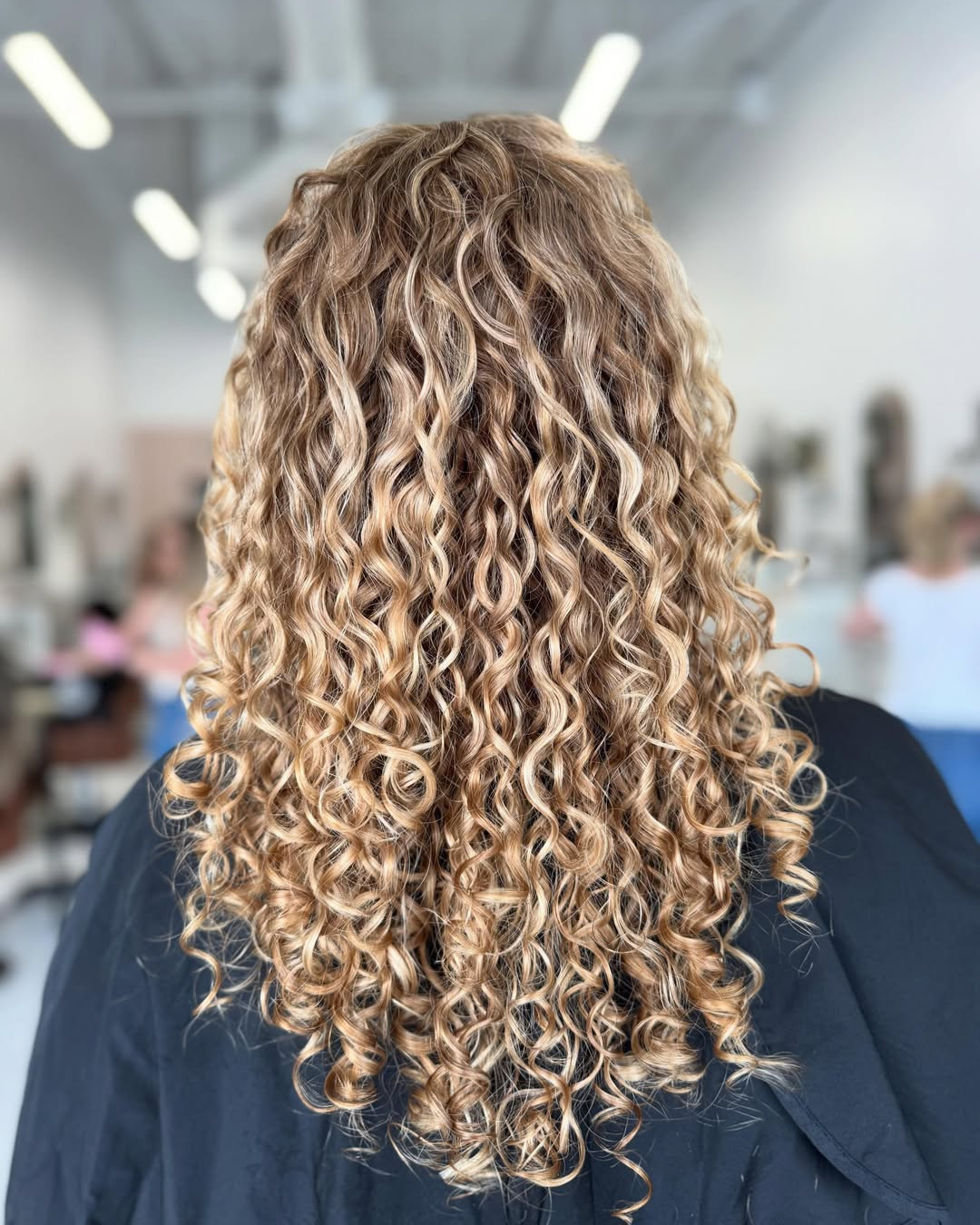 Long honey blonde curly hairstyle with defined ringlets by Katie.