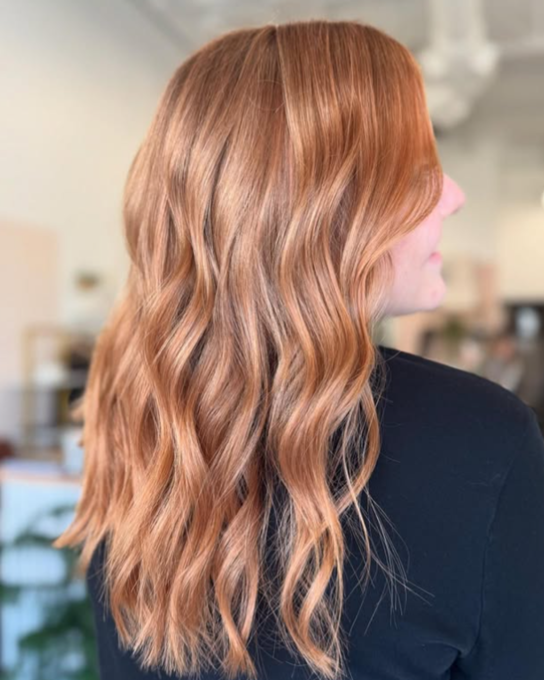Side profile of long, wavy peachy-blonde hair with soft dimensional warmth by Zoe.
